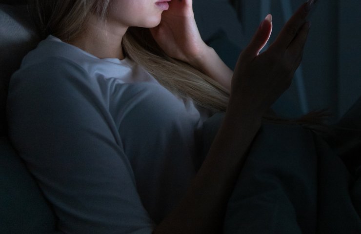 Una ragazza con lo smartphone a letto