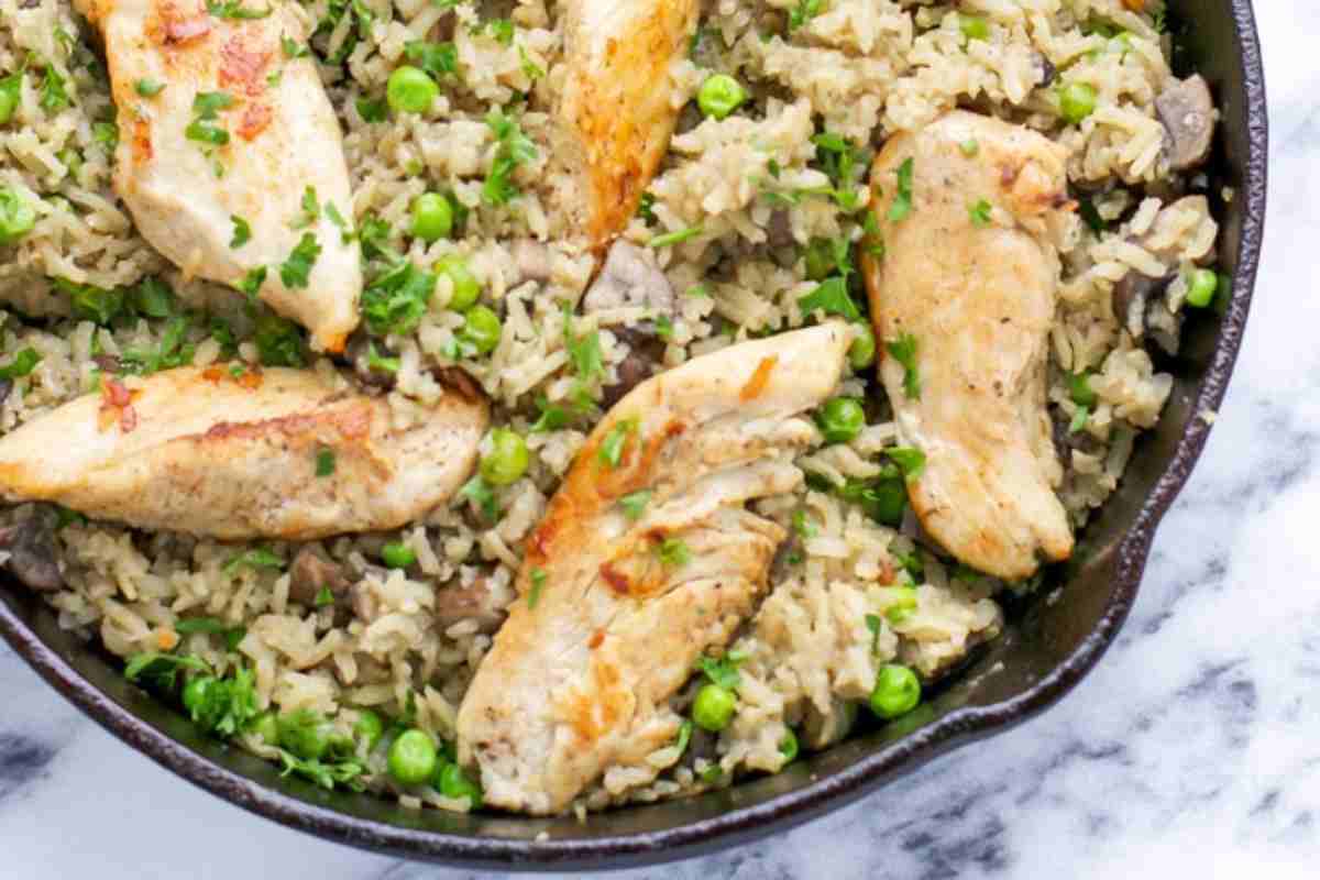 Una padella con riso con pollo e zucchine