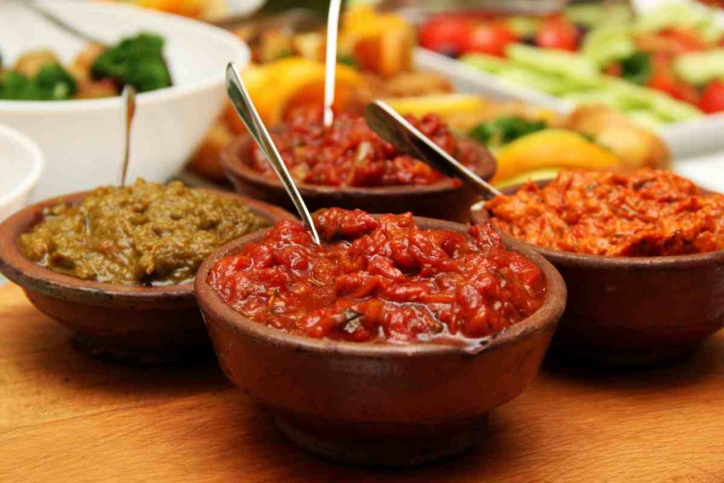 varie ciotole con salse per melanzane grigliate
