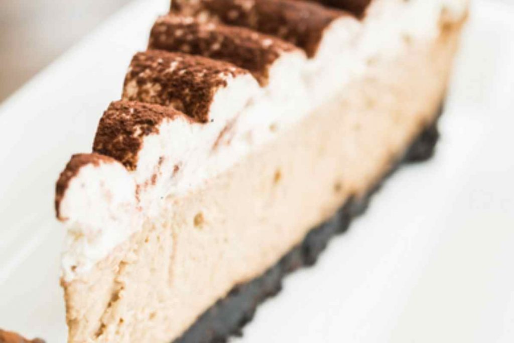 Fetta di torta alla crema di caffè e panna in un piatto