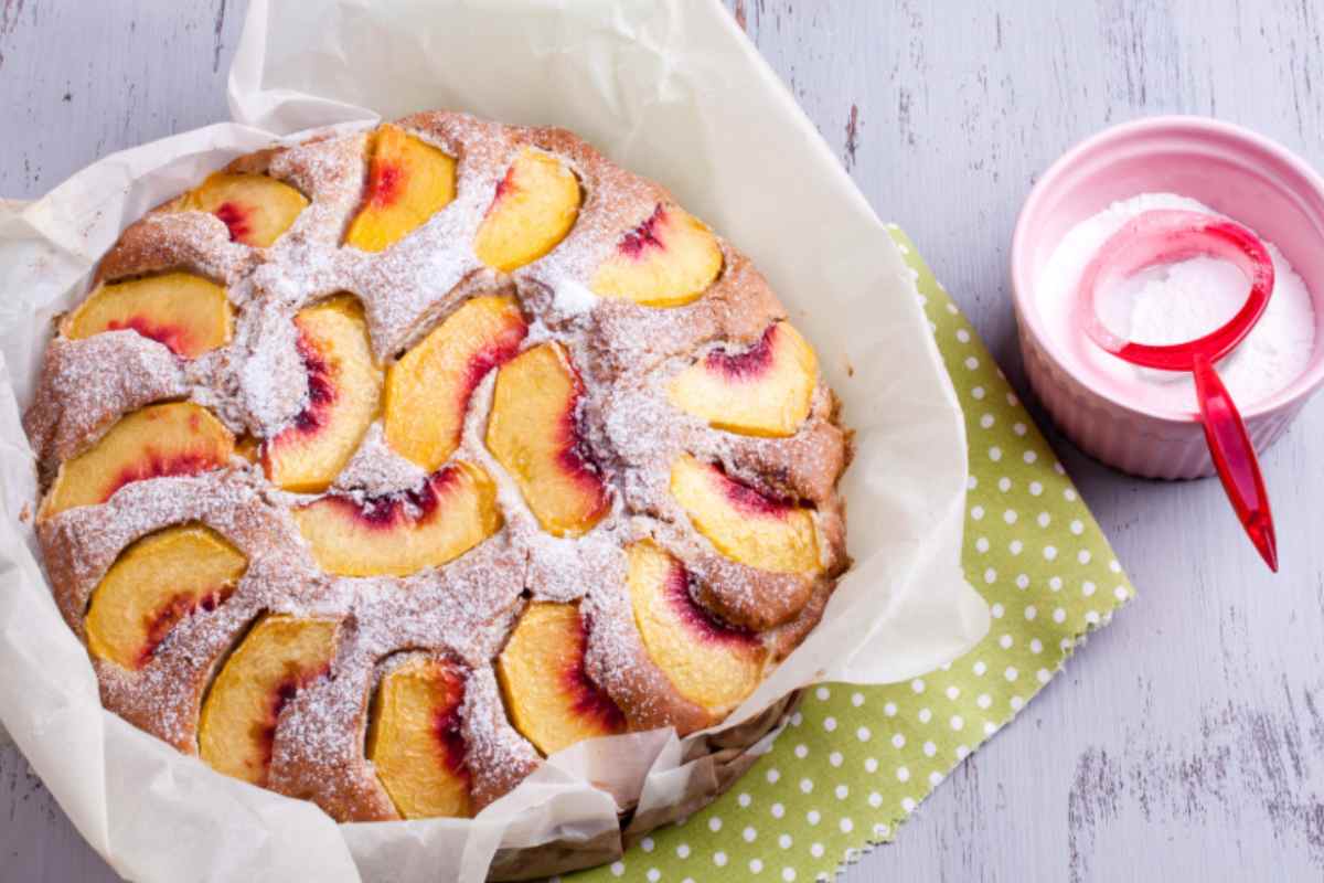 Torta con le pesche e zucchero a velo