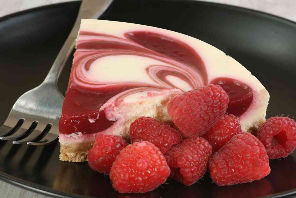 Torta estiva con ricotta e lamponi per decorazione con vicino una forchettina