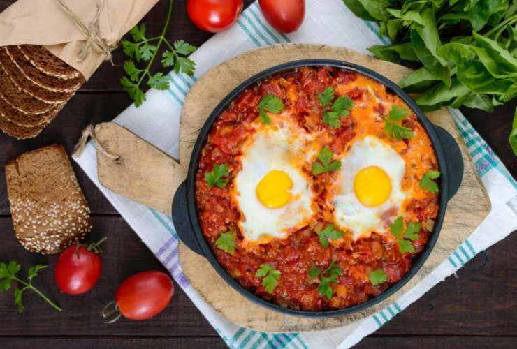 Uova con sugo e prezzemolo in un tegame nero