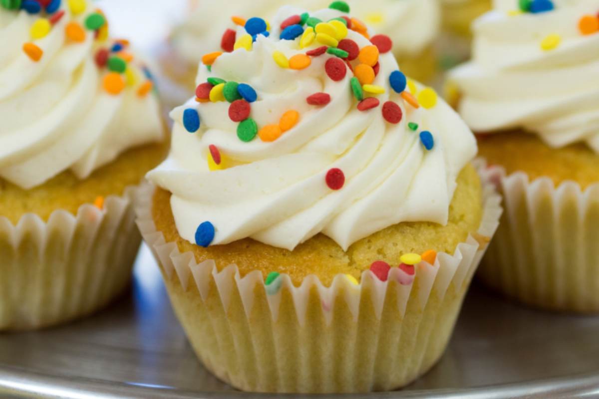 Cupcake guarnito con crema e codette colorate di zucchero