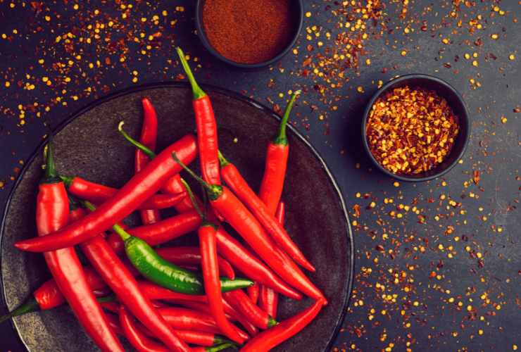 peperoncino fresco in una ciotola e peperoncino secco tritato in un'altra ciotola