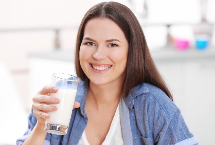 ragazza con un bicchiere di latte in mano