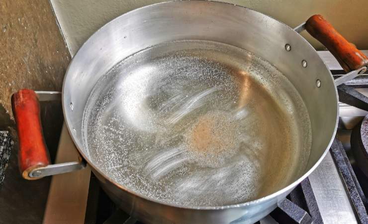 pentola con acqua che bolle con fondo rovinato