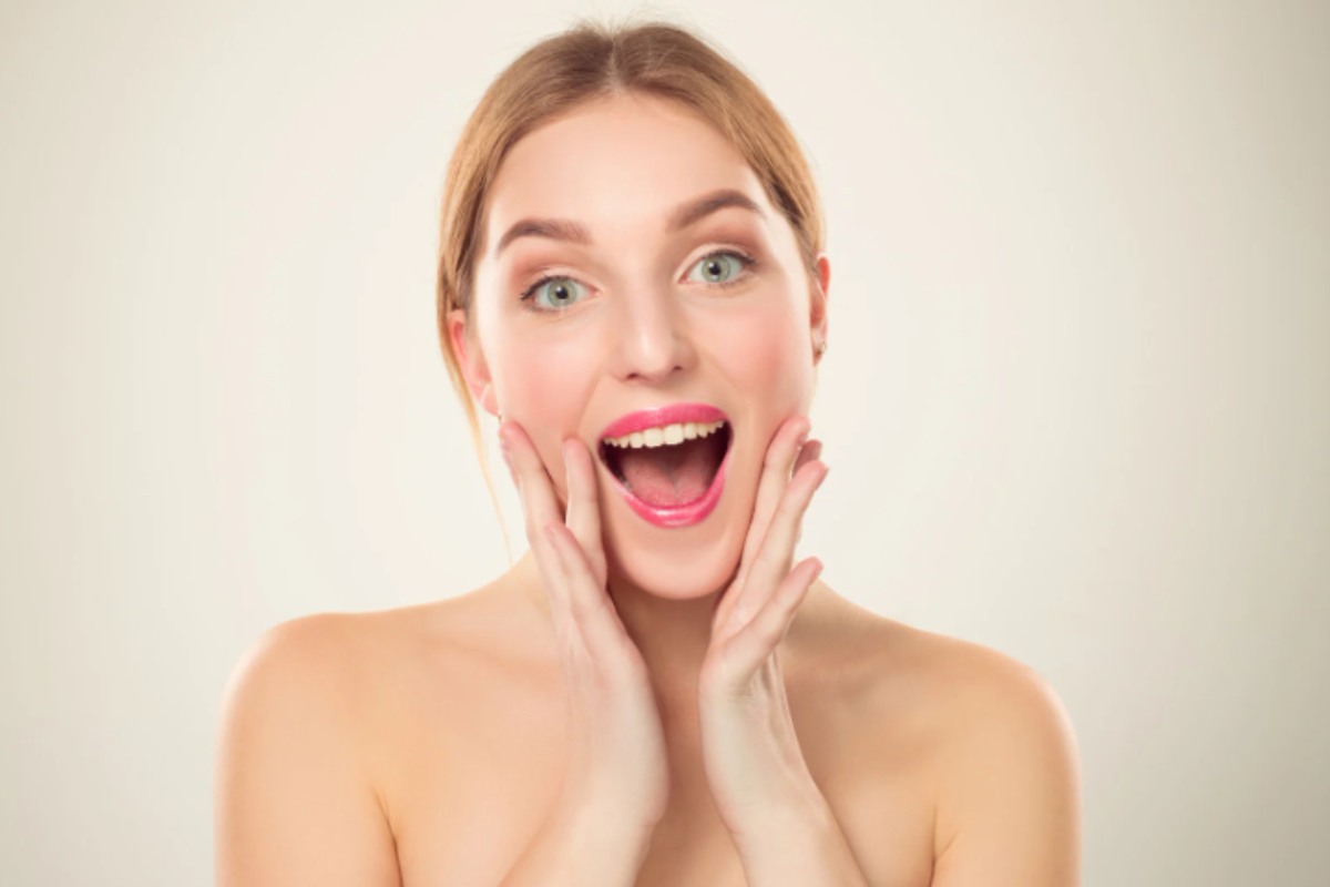 donna che sorride e si tocca il viso