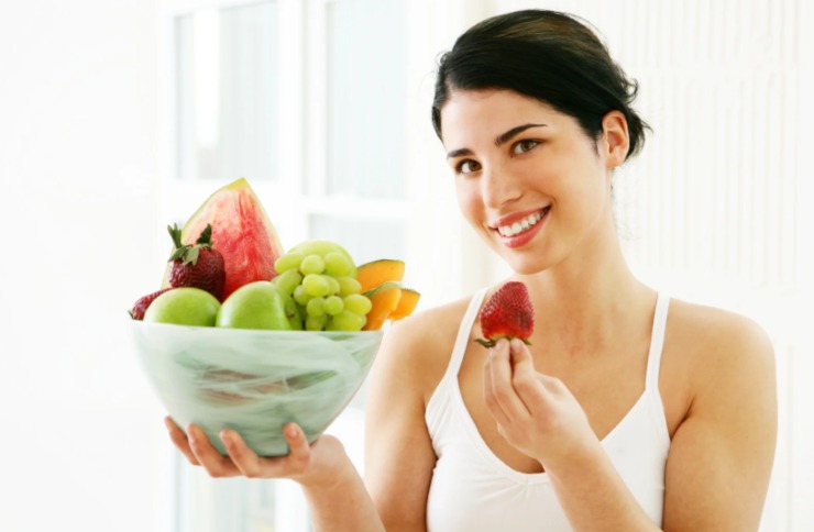 donna con in mano una ciotola piena di frutta