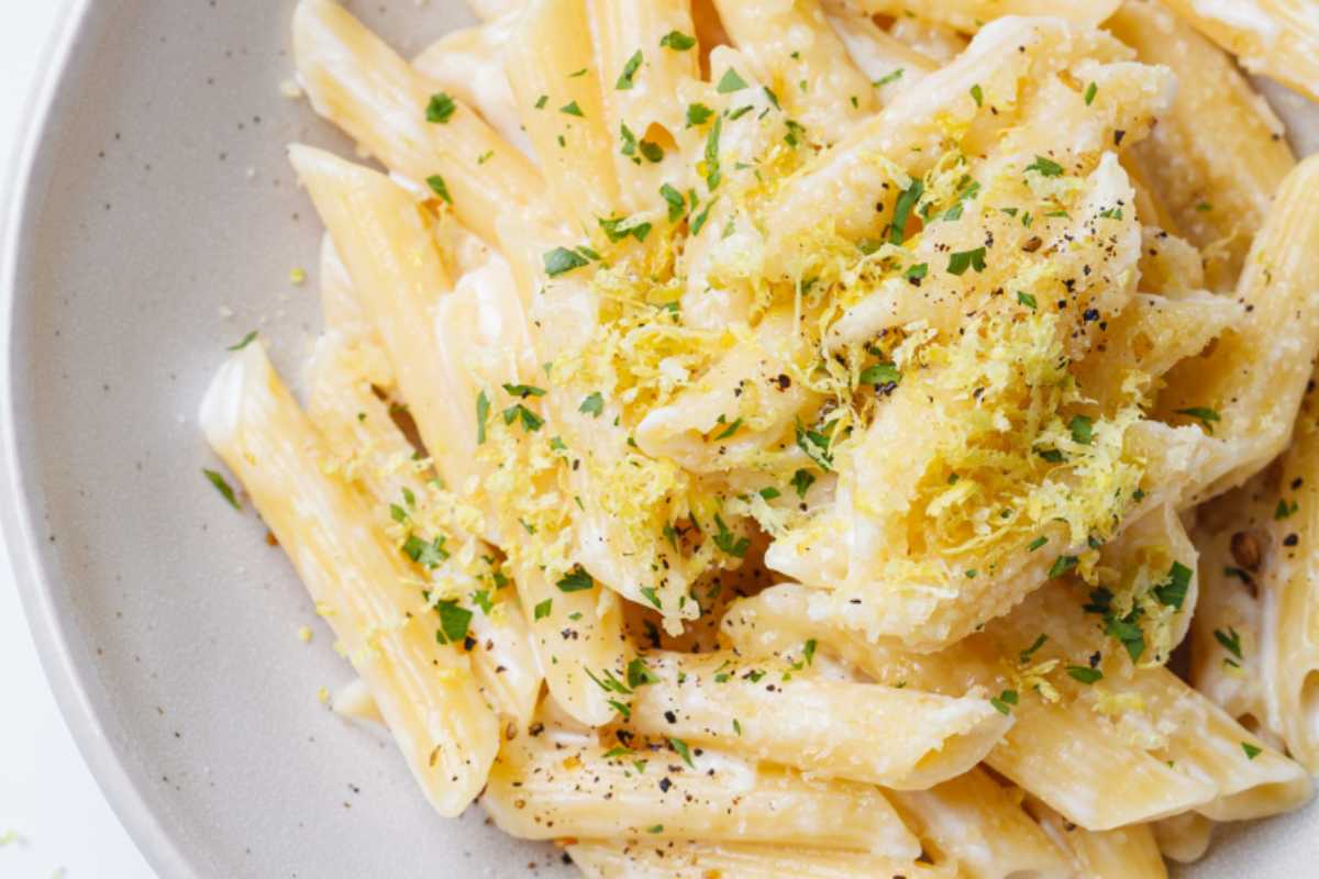 piatto di penne cremose con buccia di limone grattugiata