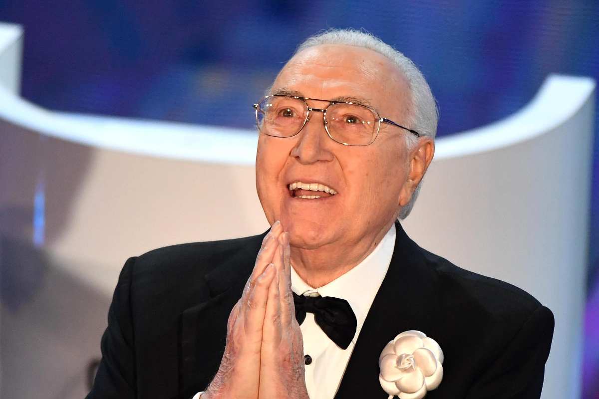Pippo Baudo che sorride con le mani giunte