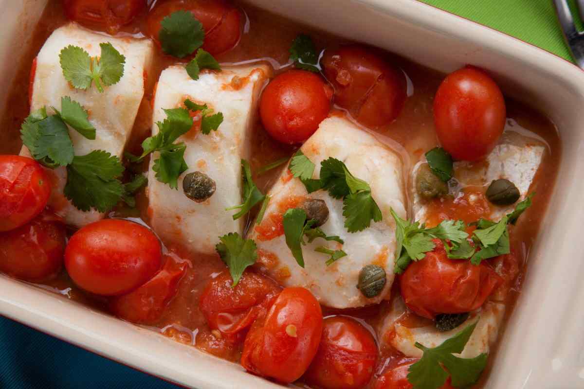 merluzzo al forno in una teglia con pomodori