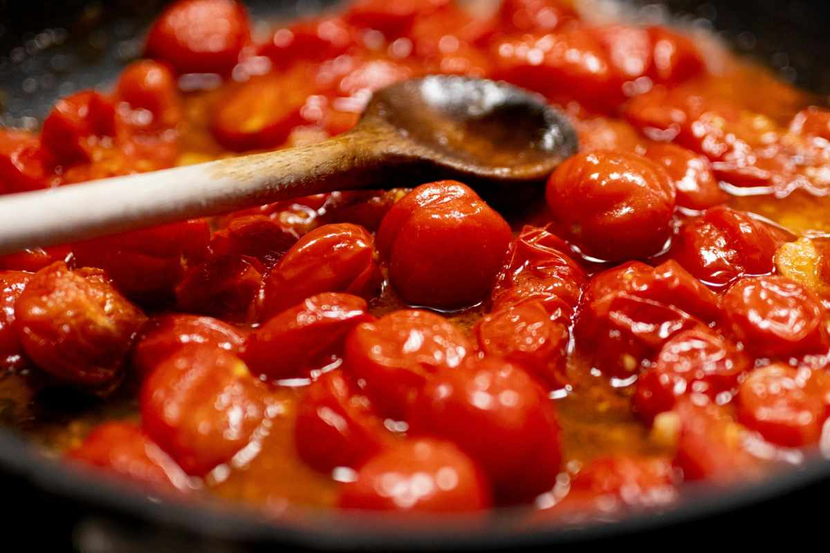 pomodori in padella con cucchiaio di legno