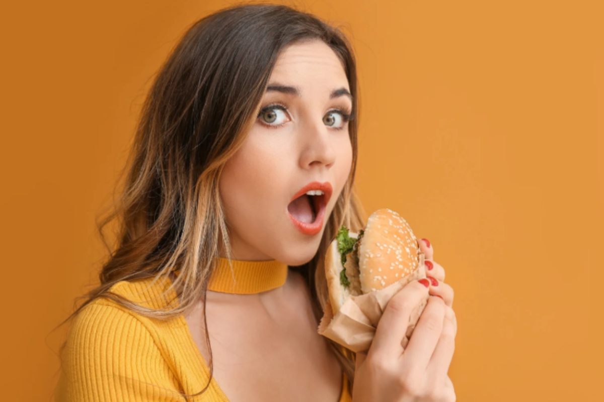 donna con in mano un hamburger