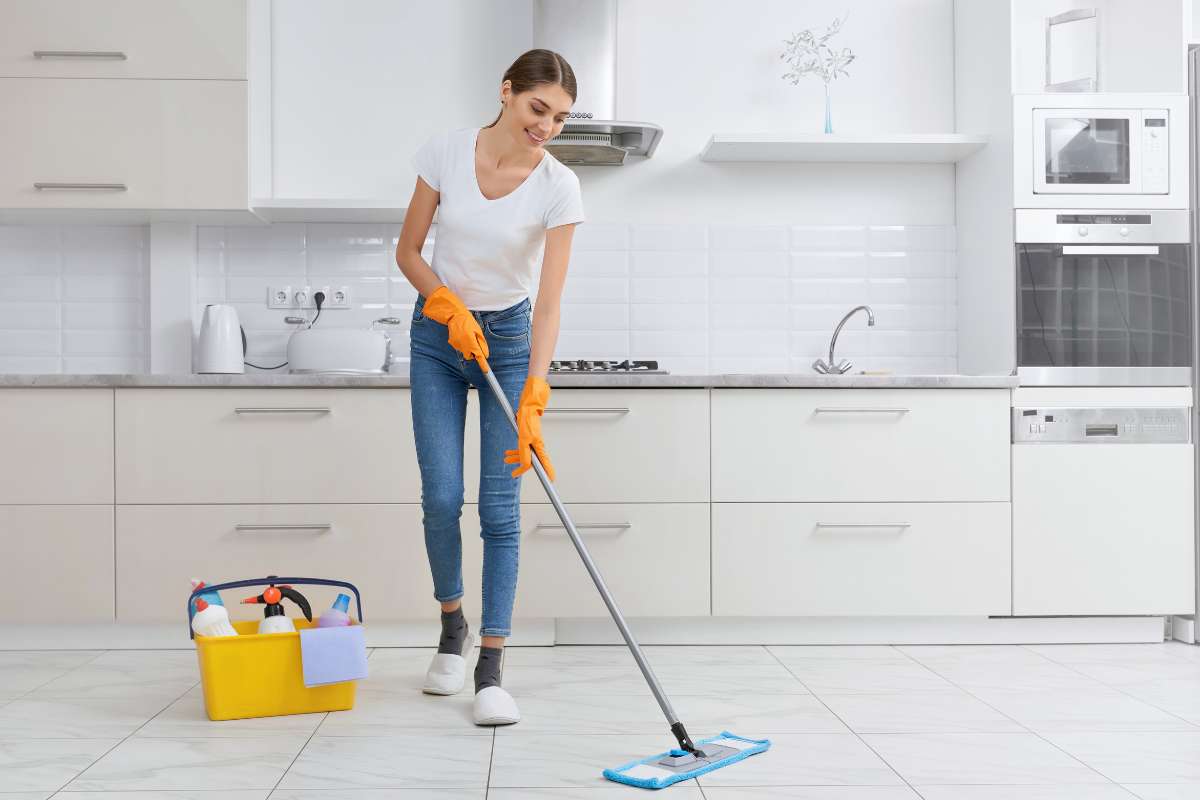 donna pulisce il pavimento della cucina