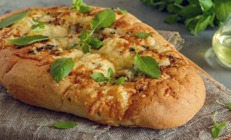 focaccia cipolle e formaggio con basilico su tagliere