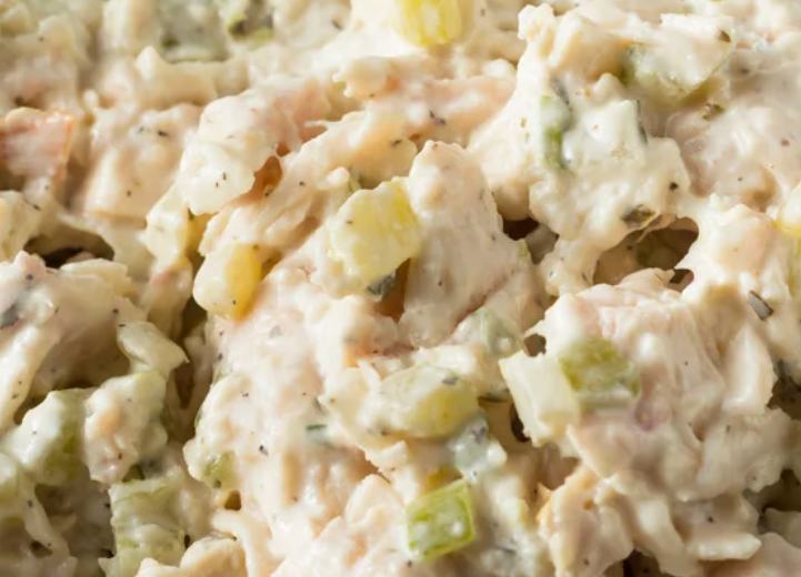 primo piano di pezzi di pollo cremosi all'insalata