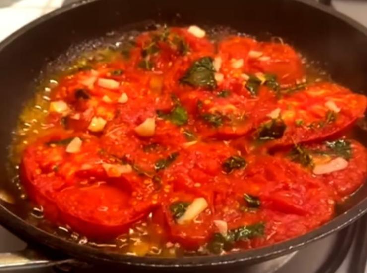 pomodori che cuociono in padella con aglio e spezie