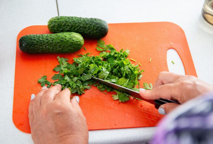 tagliare il prezzemolo e due cetrioli sul tagliere