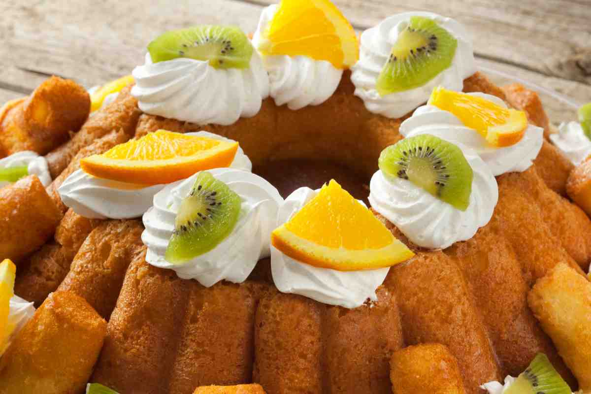 corona di babà all'arancia con panna montato, pezzetti di kiwi e di arance