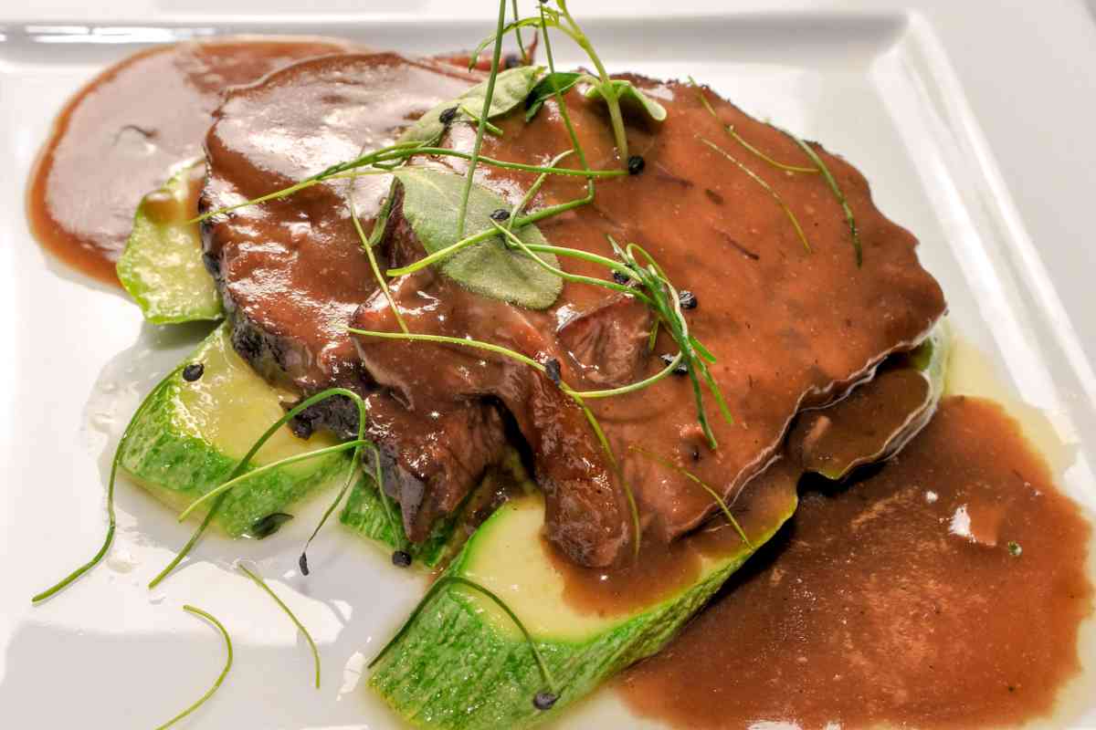 piatto con fette di brasato al Barolo e zucchine di contorno
