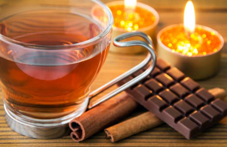 Una tazza di tè e del cioccolato fondente con della cannella