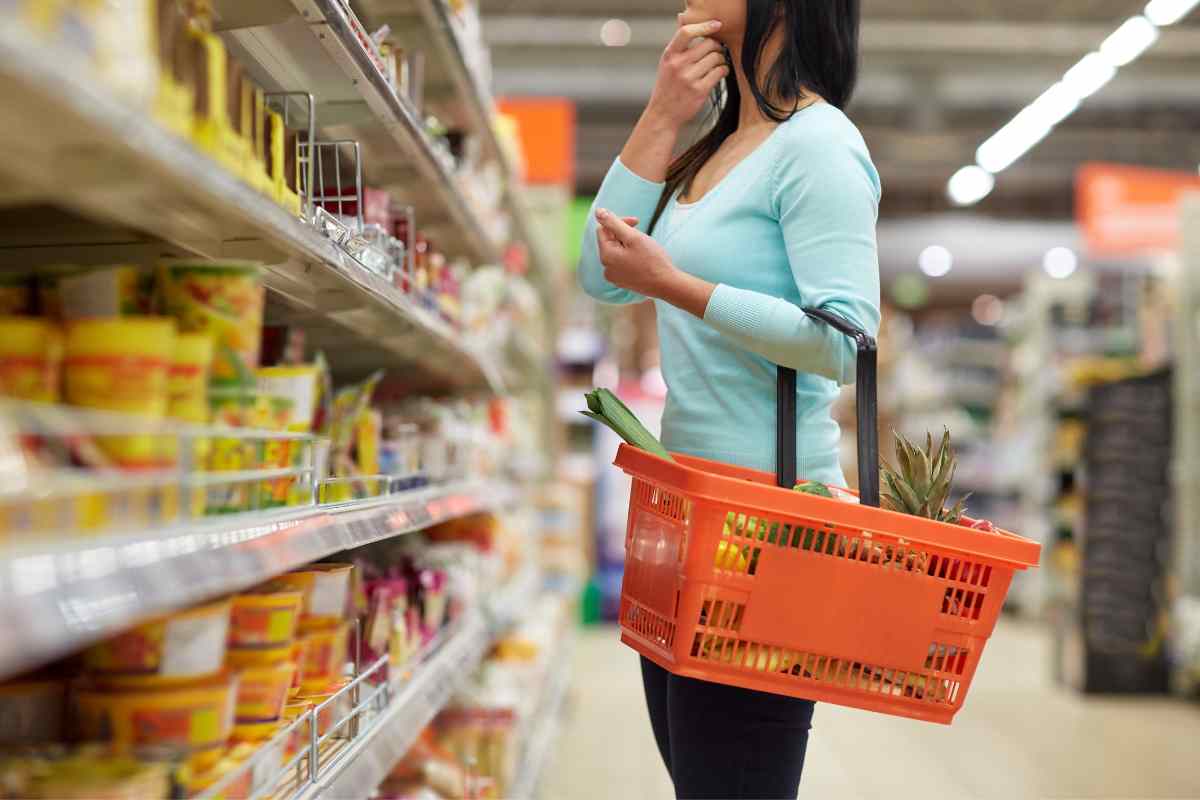 Una donna con un cestino che fa la spesa