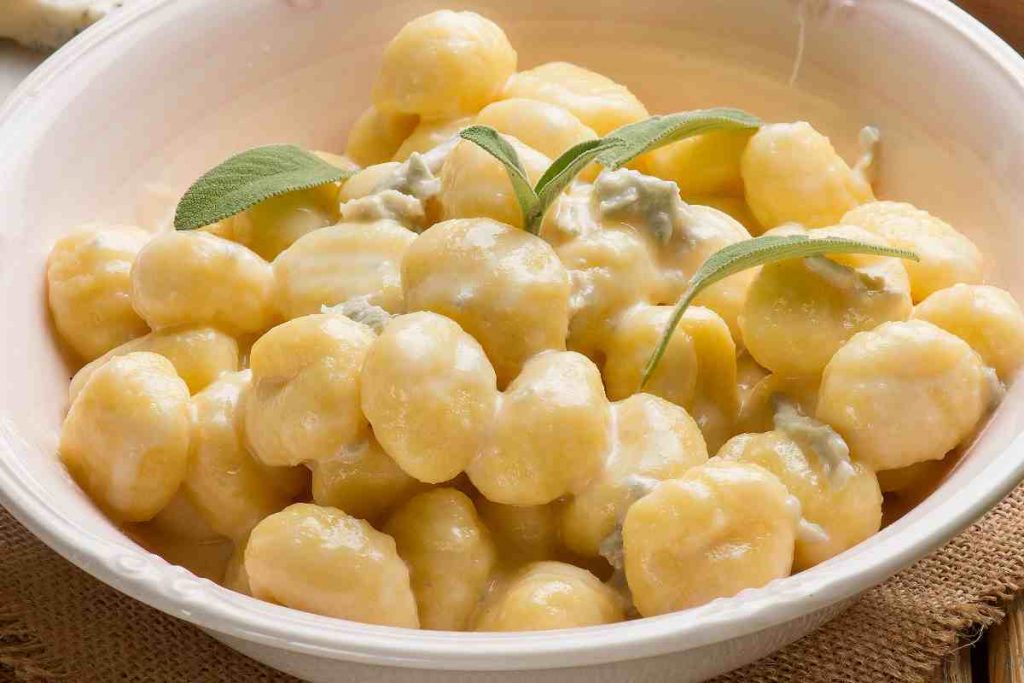 piatto con gnocchi conditi con gorgonzola e decorato con foglie di salvia
