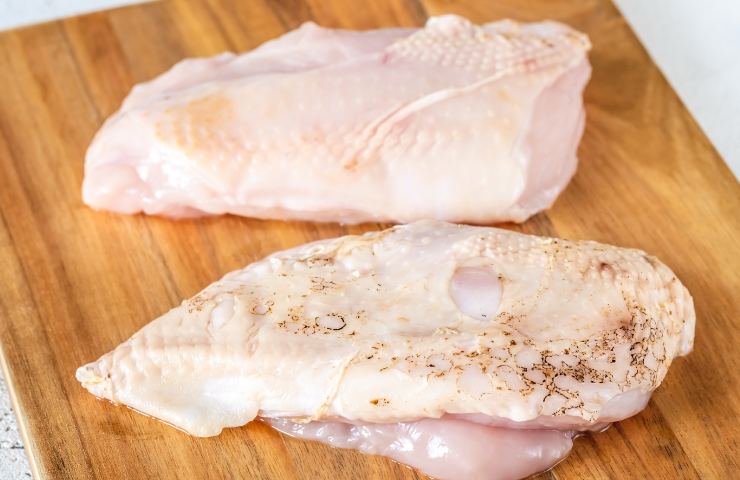 Del petto di pollo su un piano