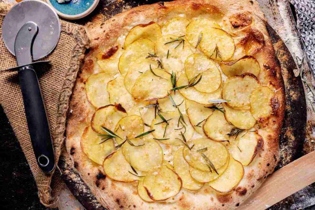 Pizza con le patate su un tagliere vista dall'alto