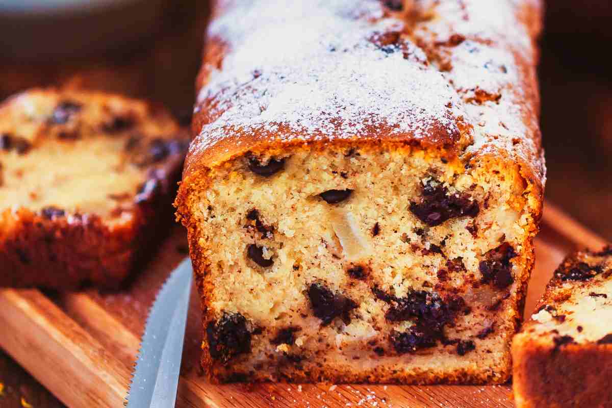 Plumcake pere e cioccolato tagliato a fette su un tagliare con vicino un coltello