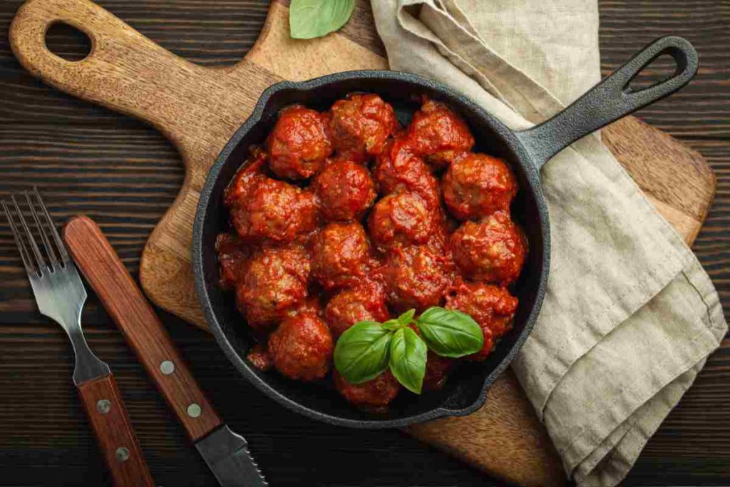padella con polpette al sugo su un tagliere vista dall'alto