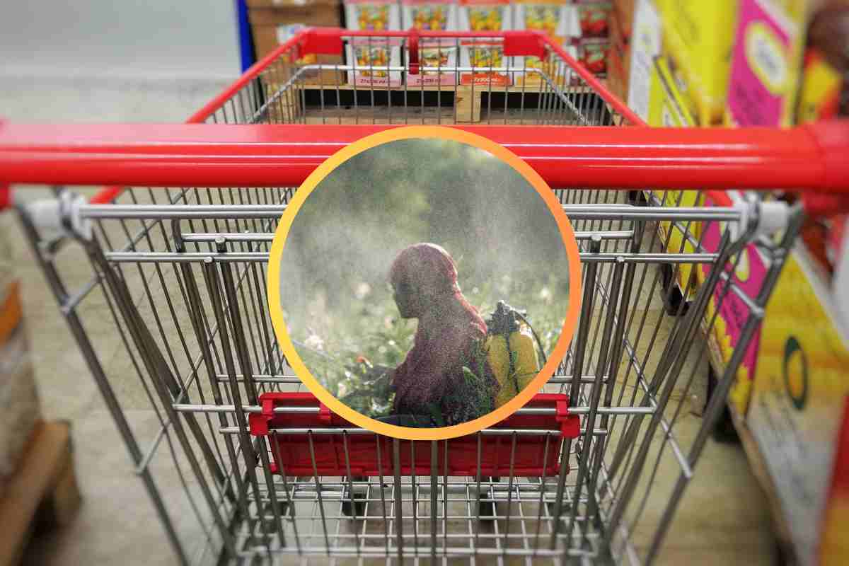 Un carrello ed un uomo che cosparge pesticidi in piccolo