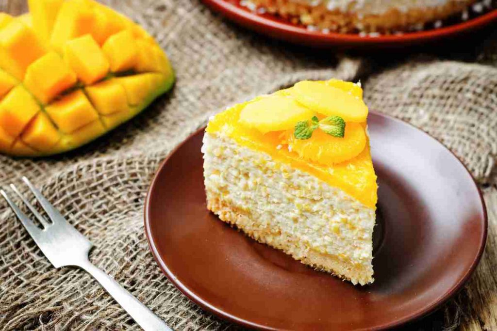spicchio di torta senza cottura mango e cocco su un piatto