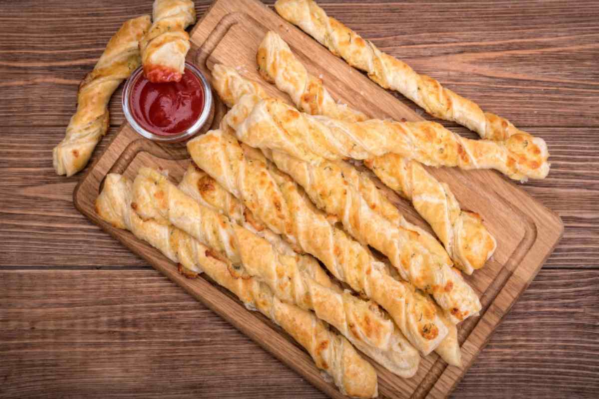 bastoncini di sfoglia ripieni su tagliere di legno