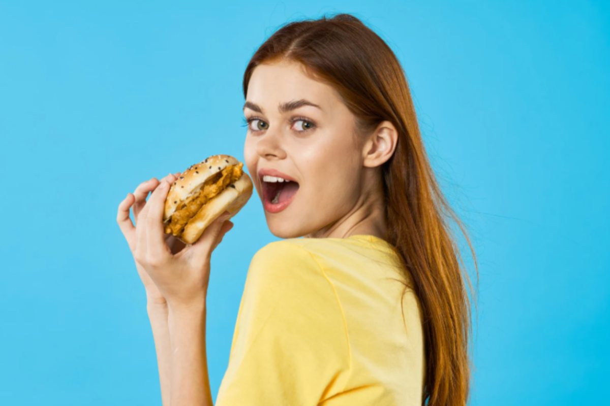 donna che mangia un hamburger