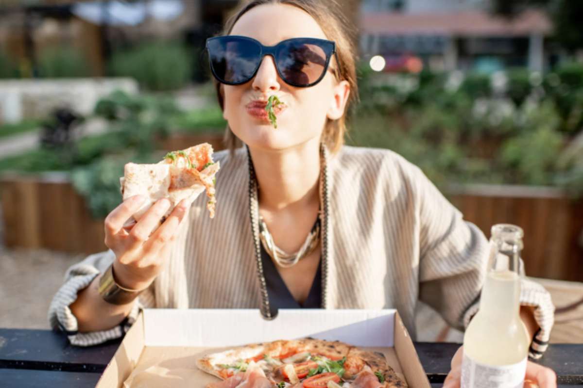 donna che mangia una pizza