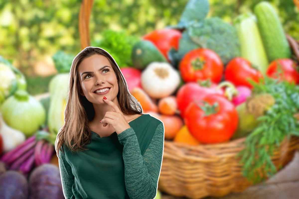 donna in primo piano e cesto di verdure miste sullo sfondo