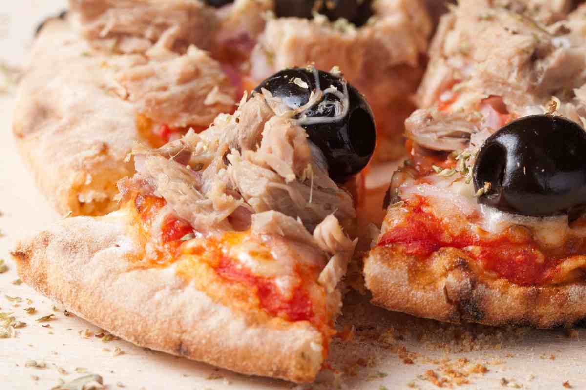 una pizza con tonno, cipolla e olive nere
