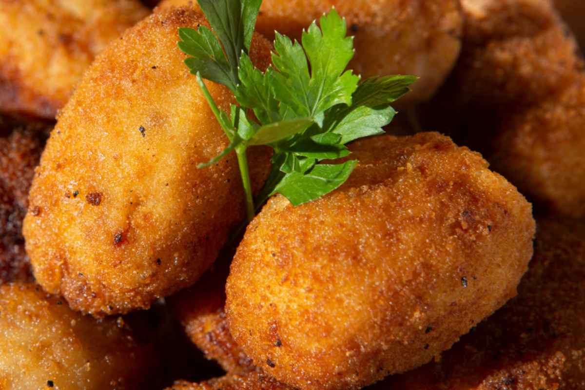 crocchette dorate con foglioline di erbe aromatiche