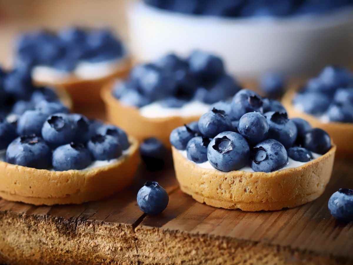 delle tartellette con crema e mirtilli