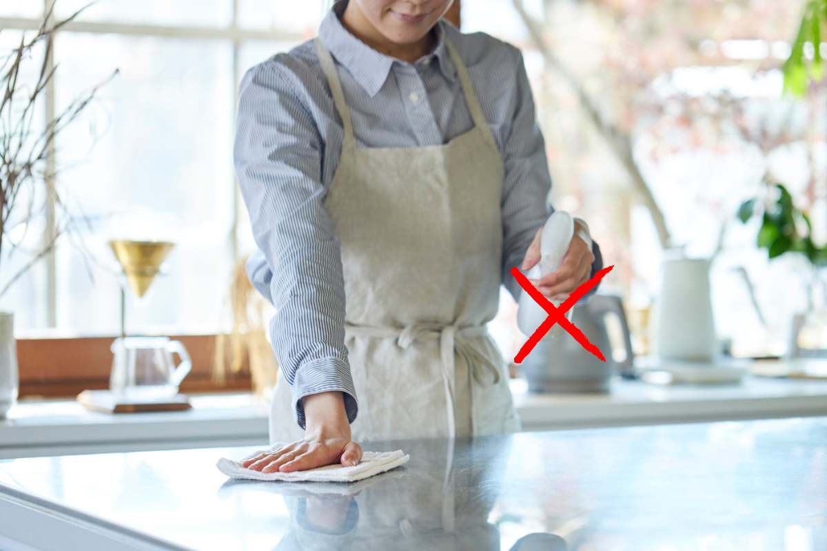 donna che pulisce piano della cucina