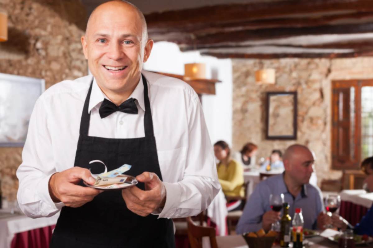 ristorante cameriere felice con in mano la sua mancia