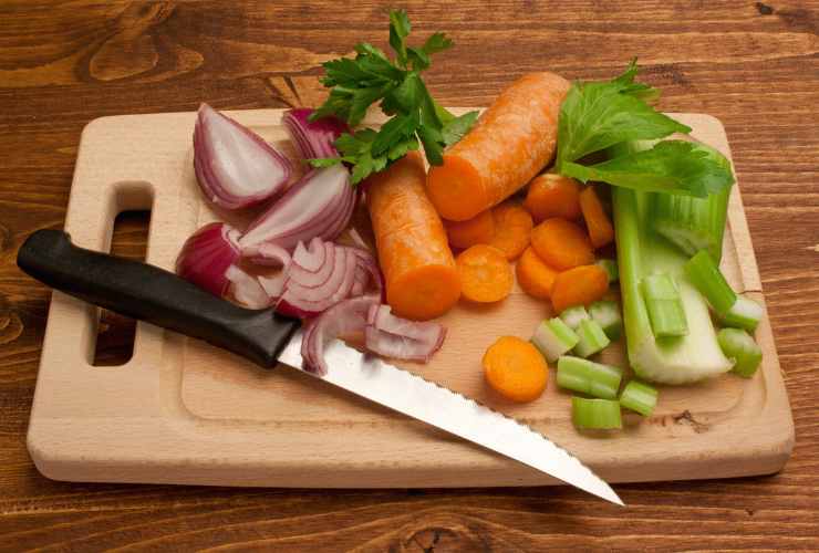 tagliere con un coltello e verdure varie