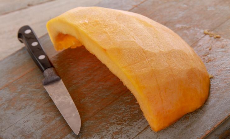 zucca sbucciata su tagliere con coltello