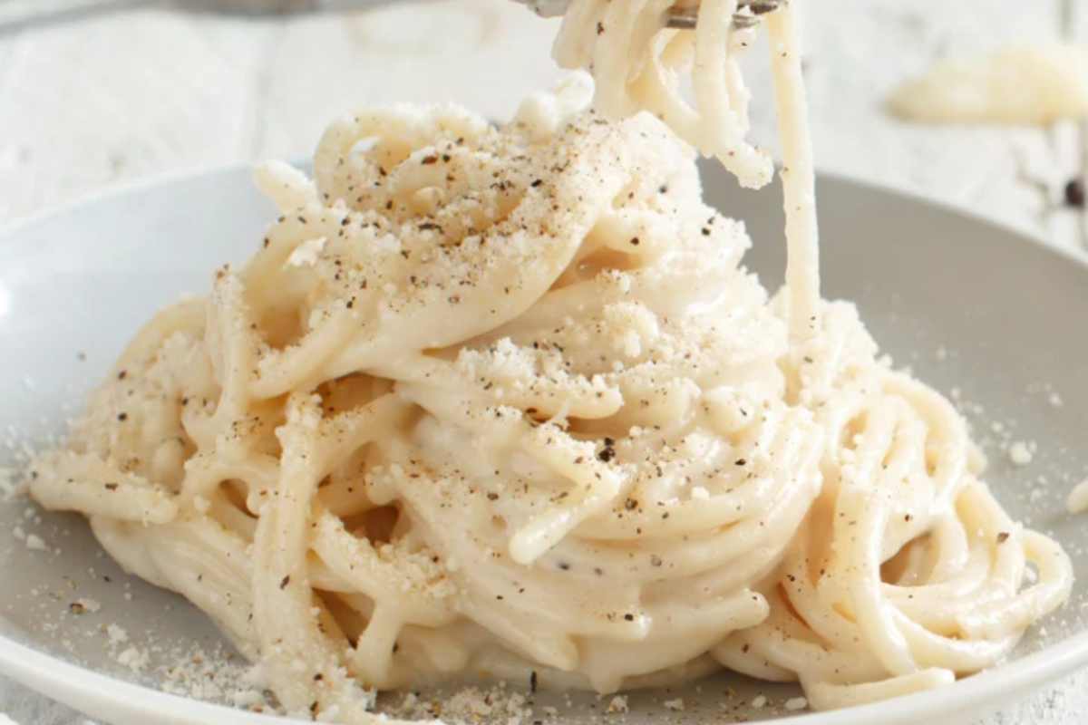 pasta cacio e pepe con panna in piatto con forchetta