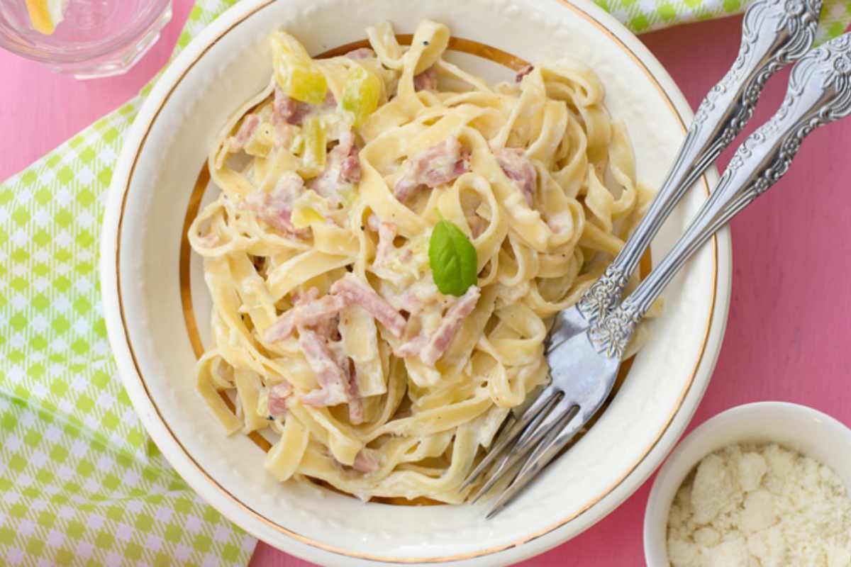 pasta cremosa con pancetta in piatto con forchette