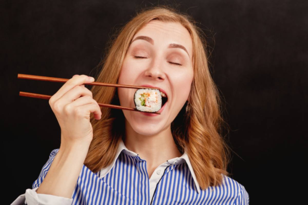 donna che mangia un rotolino di sushi