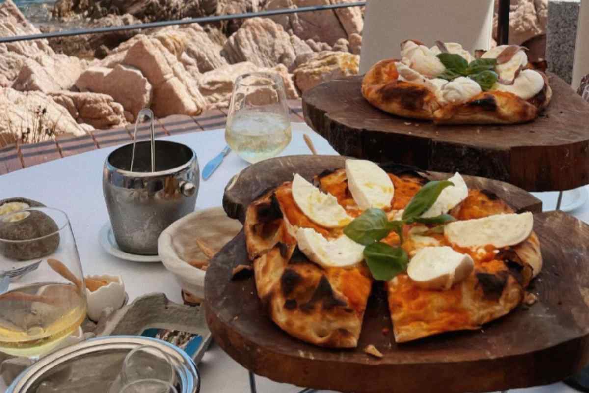 pizza con pomodoro e spicchi di mozzarella a crudo su un tagliere di legno