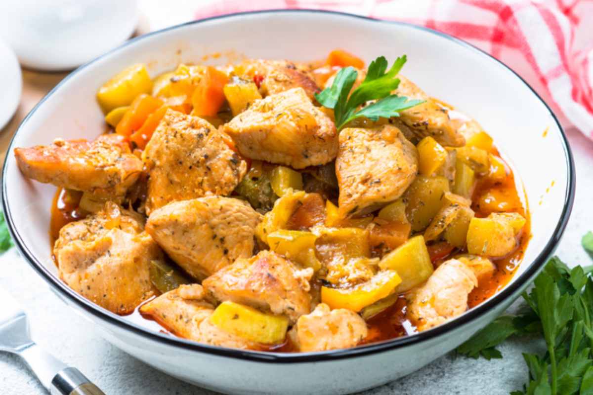 pollo con patate in un piatto con sugo di pomodoro